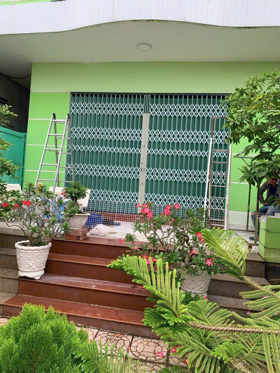 Nhà xanh, cửa kéo xanh, chậu hoa