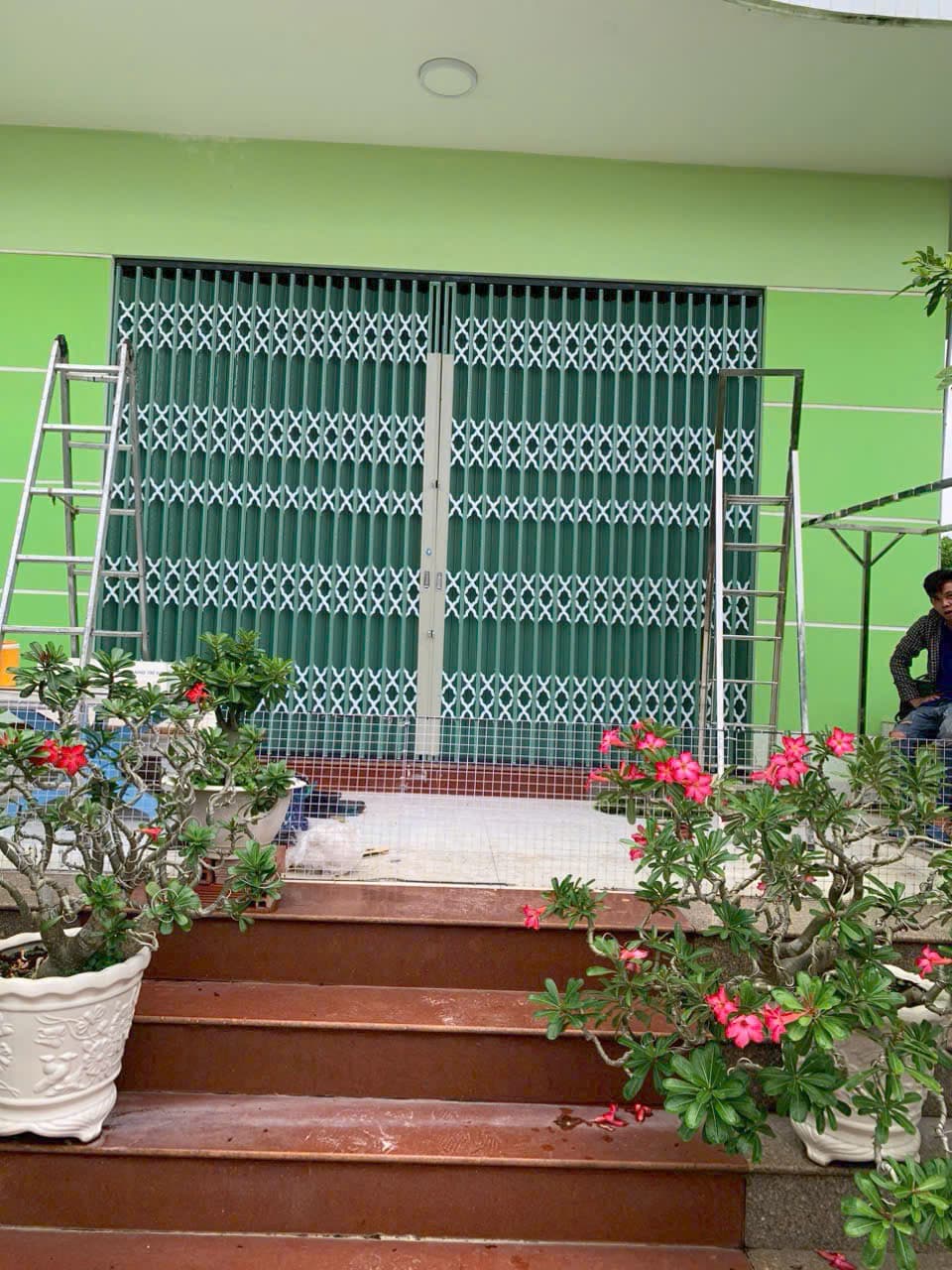 Nhà xanh, cửa kéo xanh, chậu hoa — ảnh 2